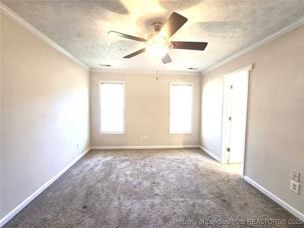 an empty room with windows and fan