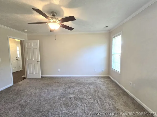 an empty room with closet and a ceiling fan