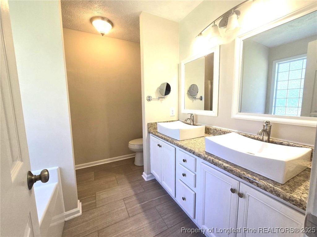 1540 Clan Campbell Drive Raeford, NC 28376 - Photo 23 of 35 a spacious bathroom with a granite countertop sink mirror and a