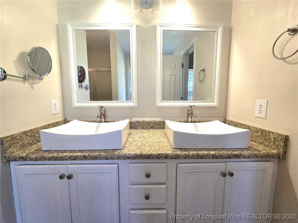 1540 Clan Campbell Drive Raeford, NC 28376 - Photo 24 of 35 a bathroom with granite countertop double vanity sinks and a mirror
