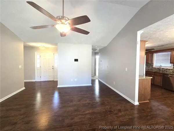 a view of a livingroom with a ceiling fan and wooden floor