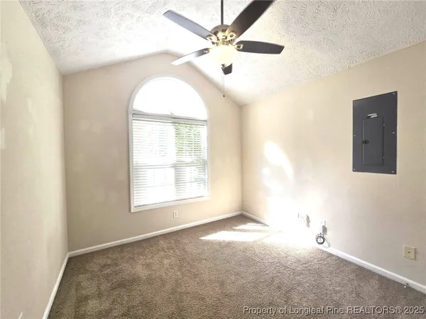 an empty room with windows and fan