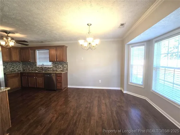 a view of kitchen with granite countertop cabinets wooden floor and a fireplace