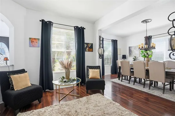 a kitchen with stainless steel appliances granite countertop a stove a refrigerator a sink dishwasher a dining table and chairs with wooden floor