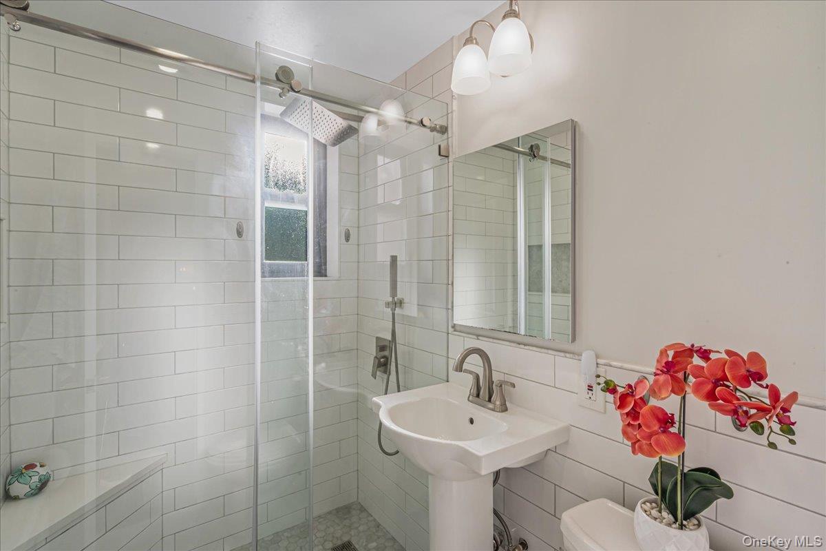 242-68 Horace Harding Expressway, Unit UPPR Queens, NY 11362 - Photo 7 of 11 a bathroom with a sink mirror and shower