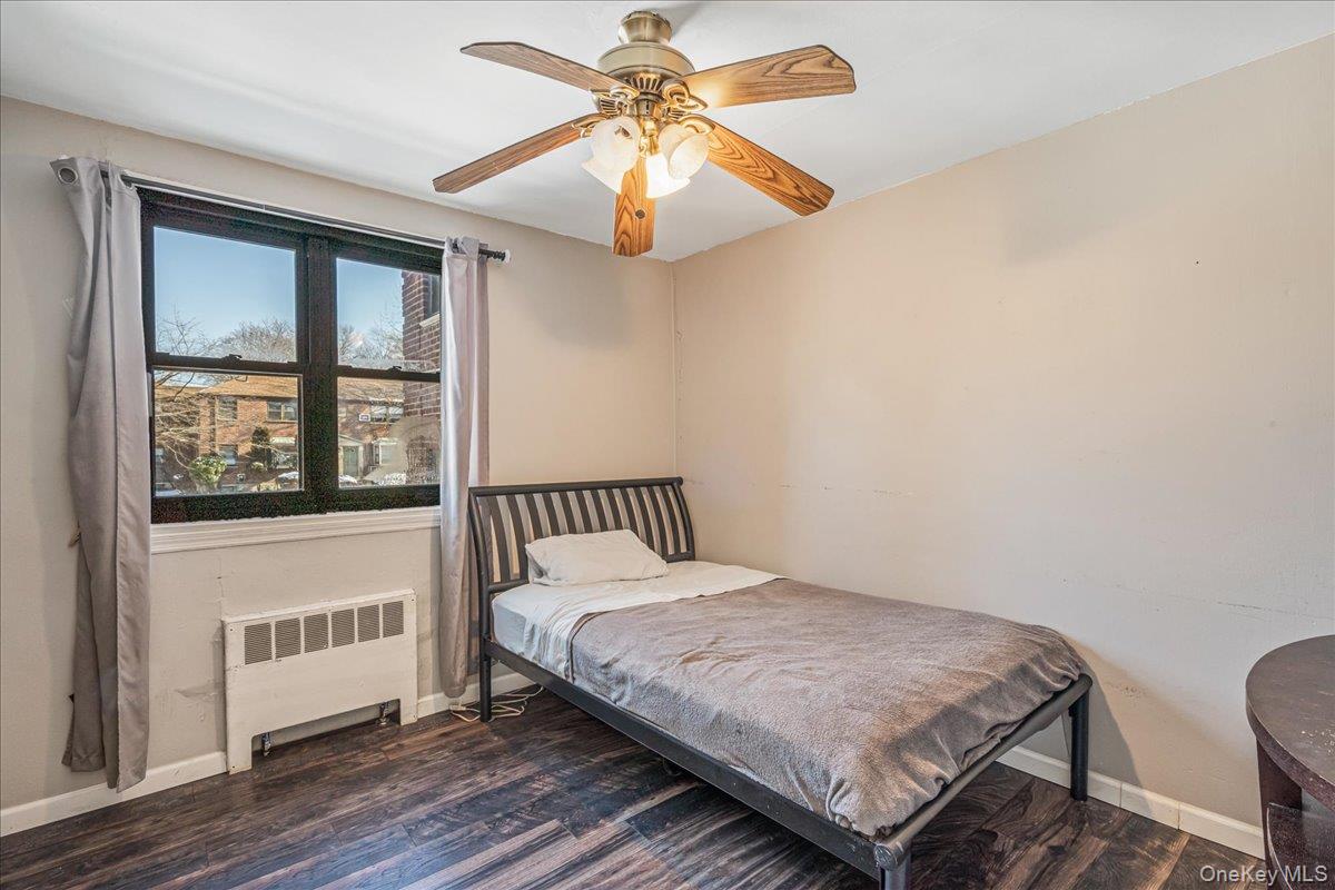 242-68 Horace Harding Expressway, Unit UPPR Queens, NY 11362 - Photo 10 of 11 a bedroom with a bed next to a window with a chandelier