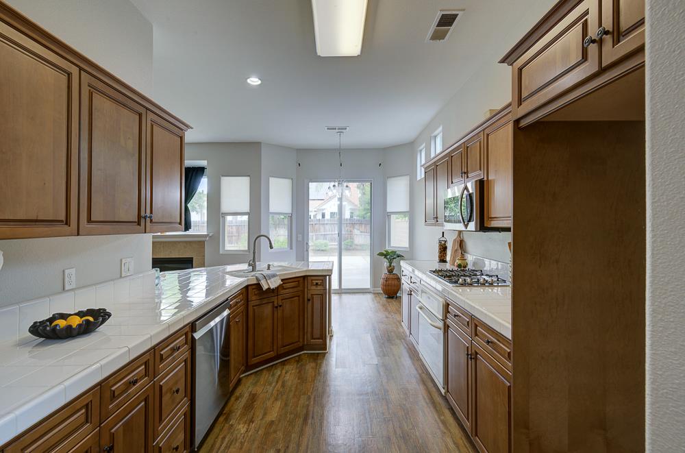 3235 Rall Avenue Clovis, CA 93619 - Photo 15 of 33 a kitchen with stainless steel appliances a sink stove and cabinets
