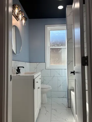 a bathroom with a toilet a sink a vanity and mirror