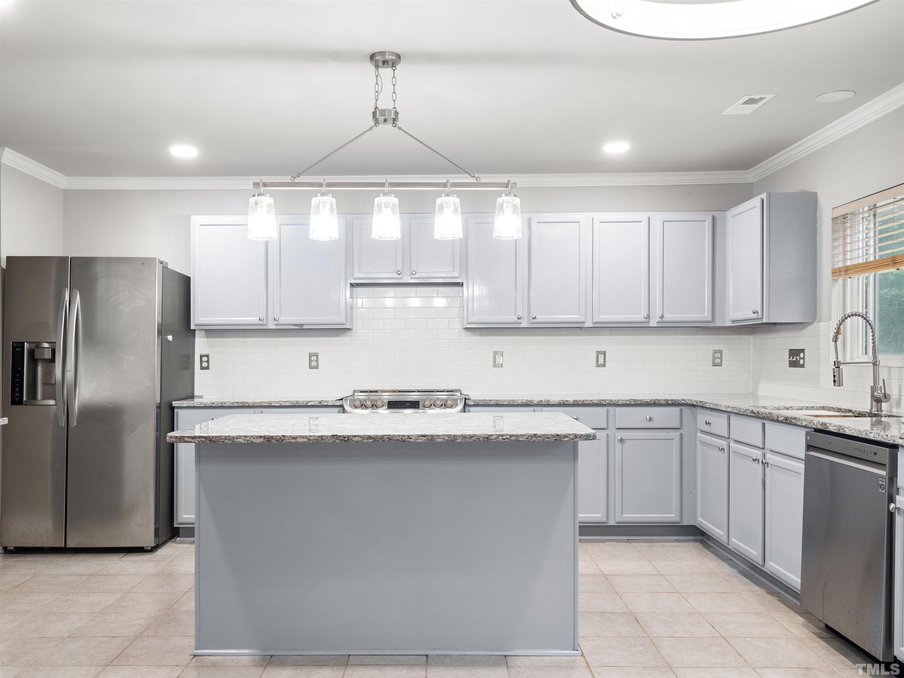4 Red Spring Court Durham, NC 27703 - Photo 11 of 35 a kitchen with stainless steel appliances a sink a stove a refrigerator cabinets and a window