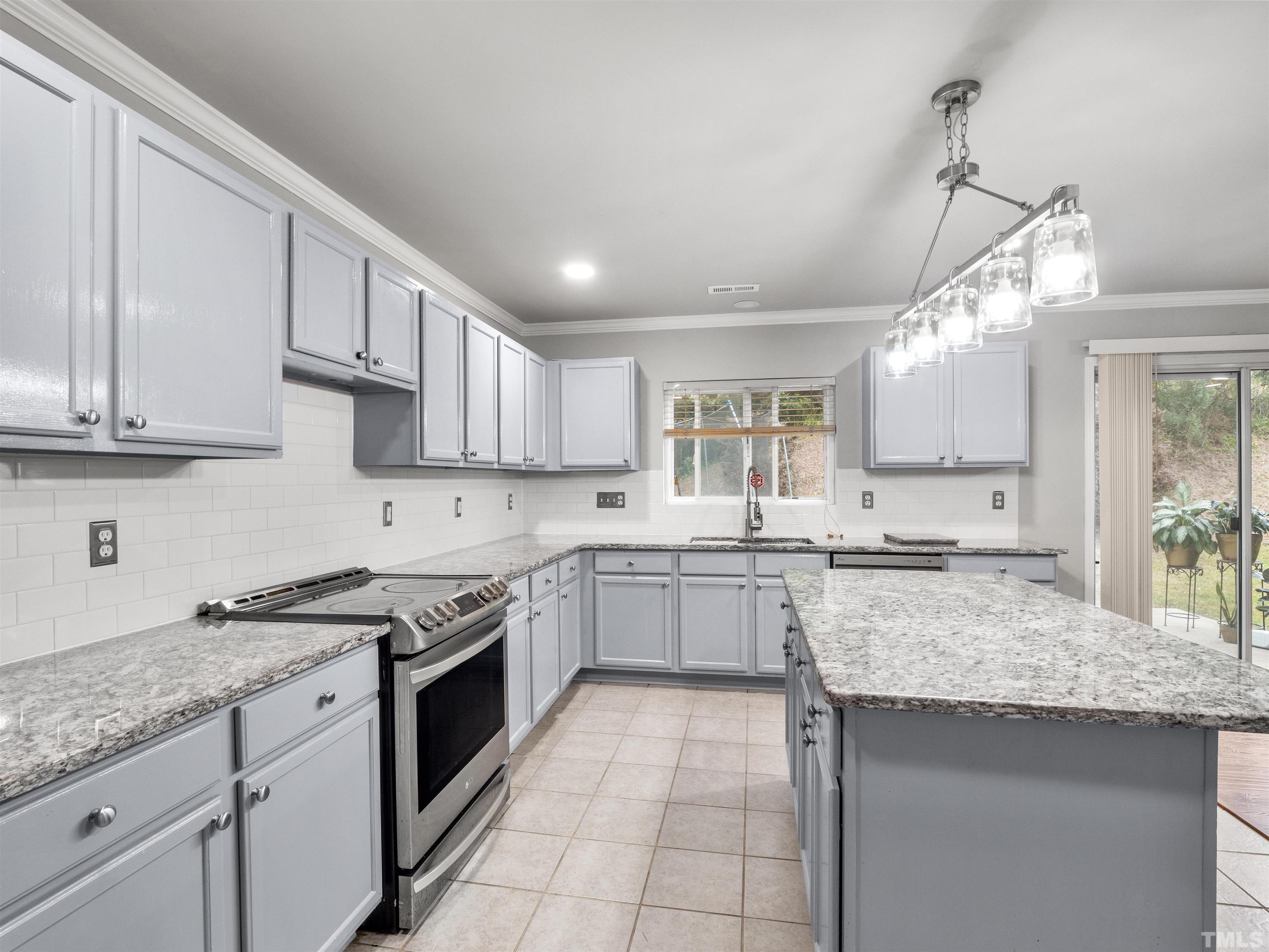 4 Red Spring Court Durham, NC 27703 - Photo 13 of 35 a kitchen with granite countertop stainless steel appliances sink stove and cabinets