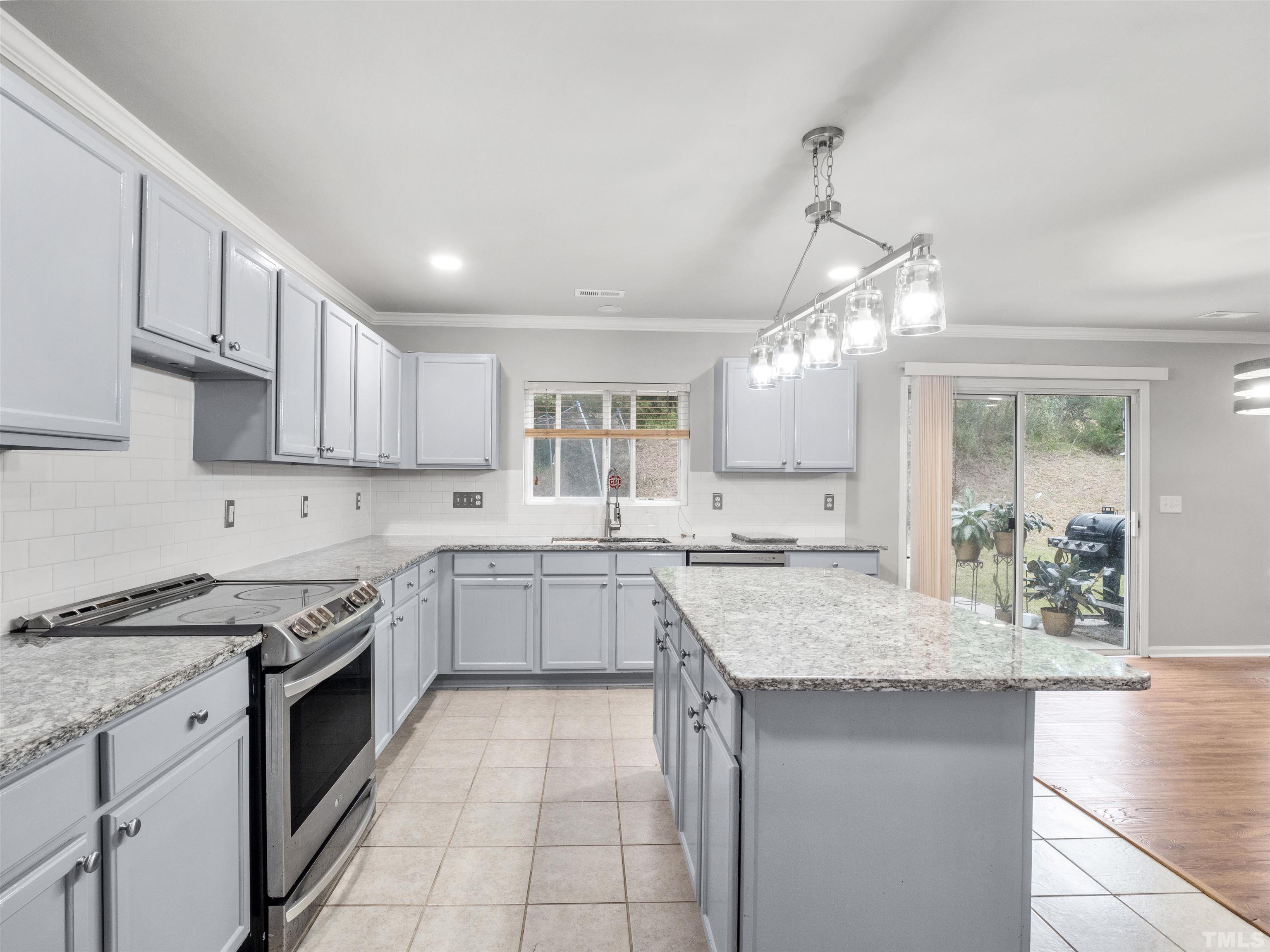 4 Red Spring Court Durham, NC 27703 - Photo 15 of 35 a kitchen with stainless steel appliances granite countertop a stove top oven a sink dishwasher and a refrigerator with wooden floor