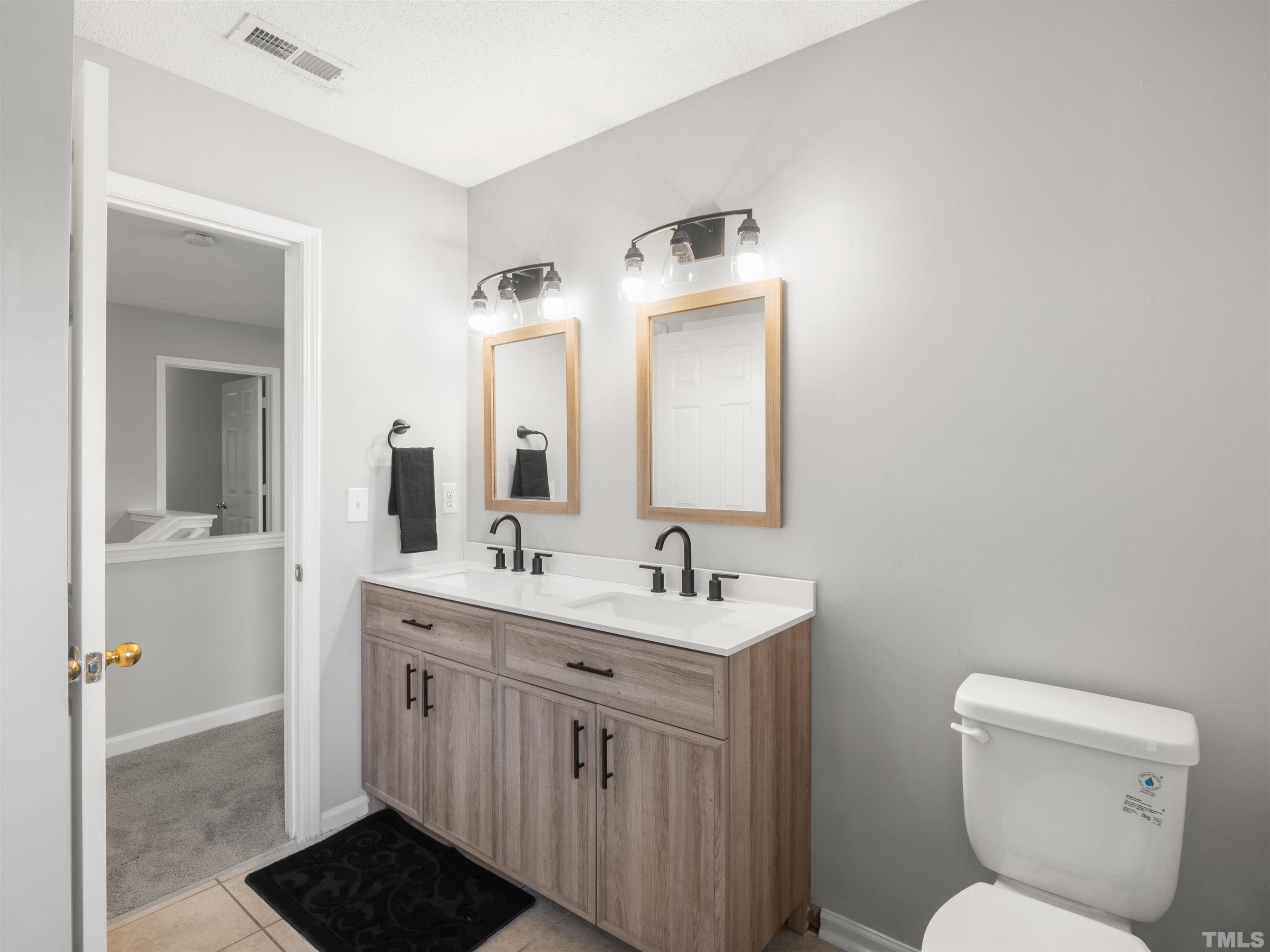 4 Red Spring Court Durham, NC 27703 - Photo 23 of 35 a bathroom with a toilet sink and mirror