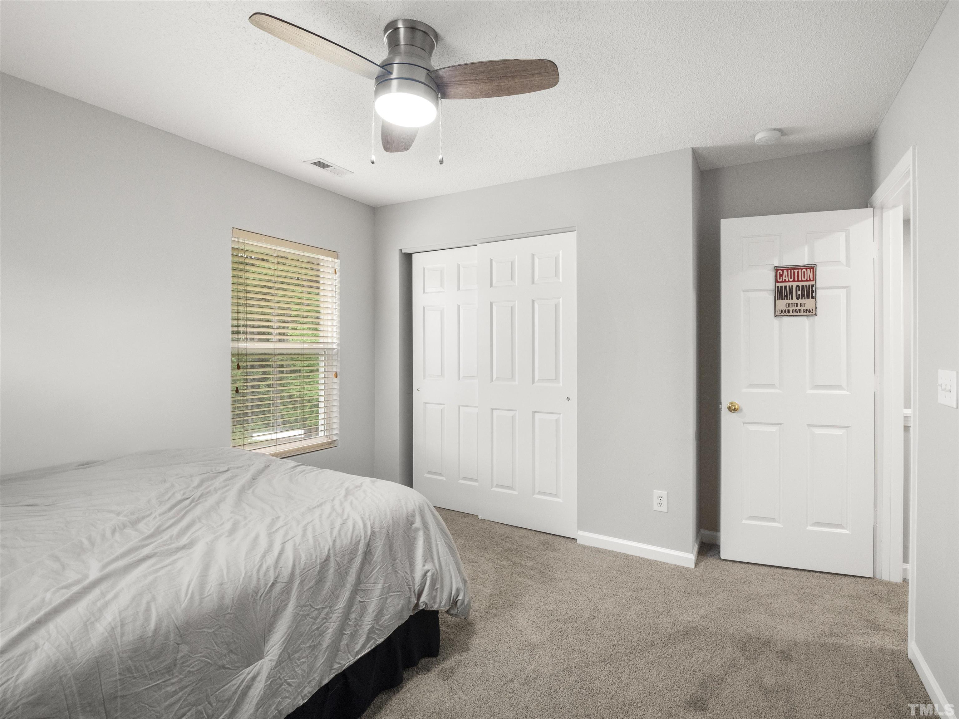 4 Red Spring Court Durham, NC 27703 - Photo 24 of 35 a spacious bedroom with a bed and a chandelier