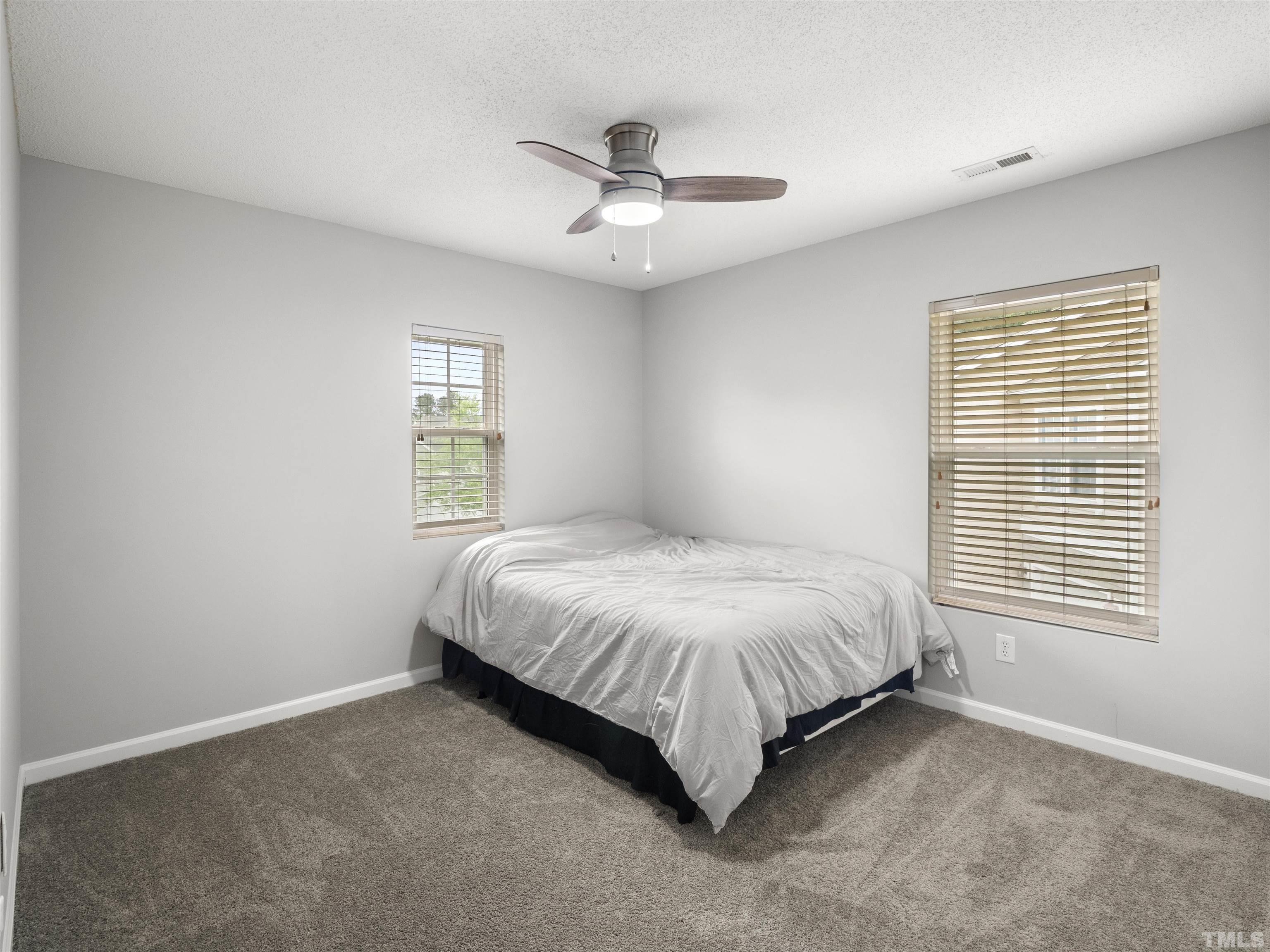 4 Red Spring Court Durham, NC 27703 - Photo 25 of 35 a spacious bedroom with a bed and window