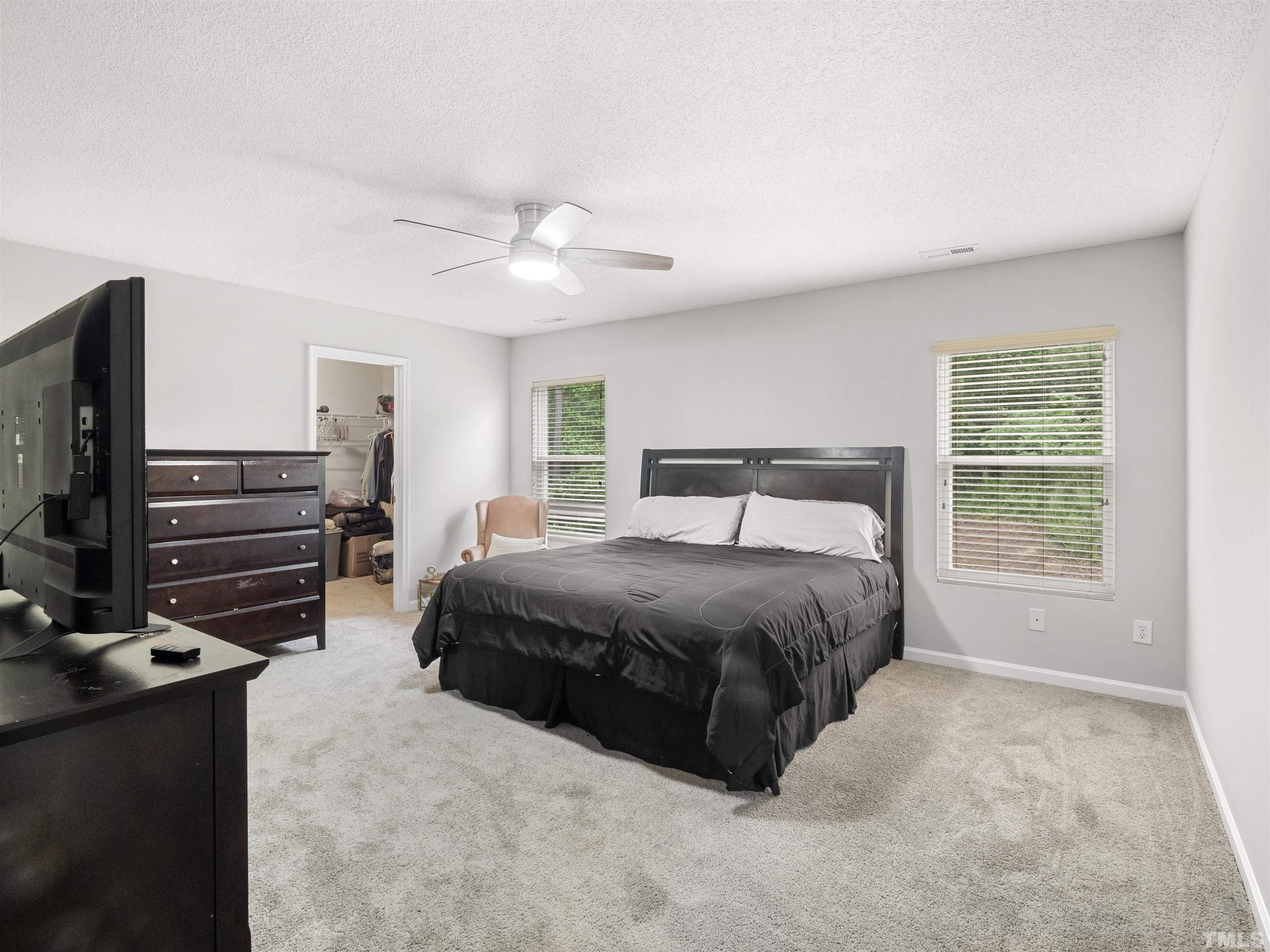 4 Red Spring Court Durham, NC 27703 - Photo 26 of 35 a bedroom with a bed and a flat tv screen on the dresser