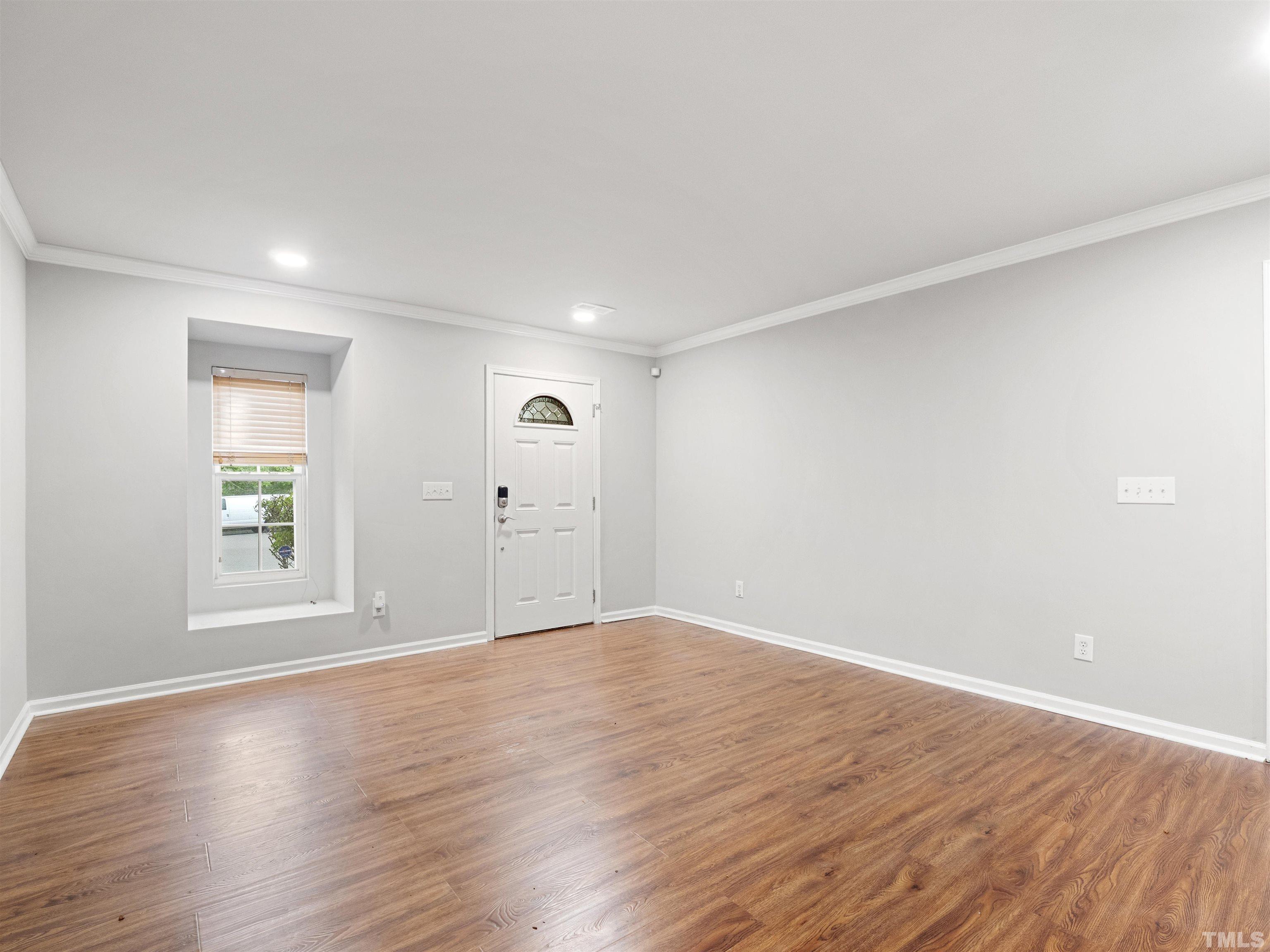 4 Red Spring Court Durham, NC 27703 - Photo 3 of 35 an empty room with wooden floor and windows