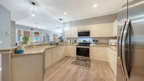 a kitchen with kitchen island a counter top space a sink stainless steel appliances and cabinets