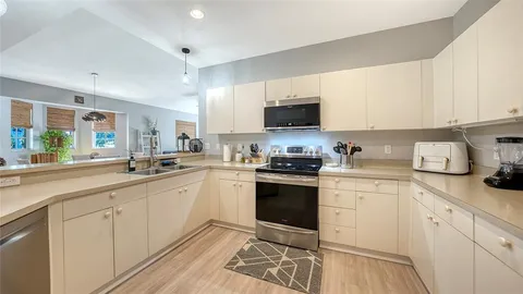 a kitchen with sink a stove and cabinets