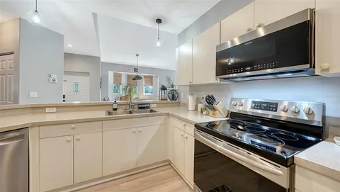 a kitchen with stainless steel appliances a sink a stove and microwave