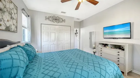 a bedroom with a bed and a flat tv screen on dresser