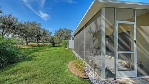 a backyard of a house with large trees and plants