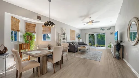 a living room with furniture a large window and a chandelier