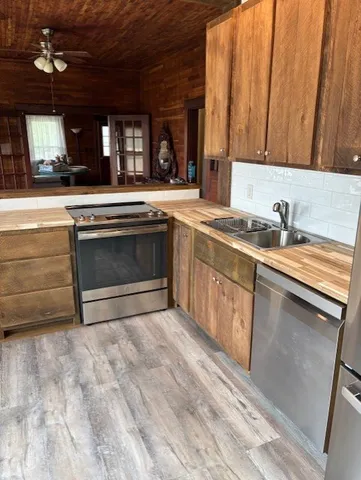 a kitchen with stainless steel appliances granite countertop a stove a sink and a microwave