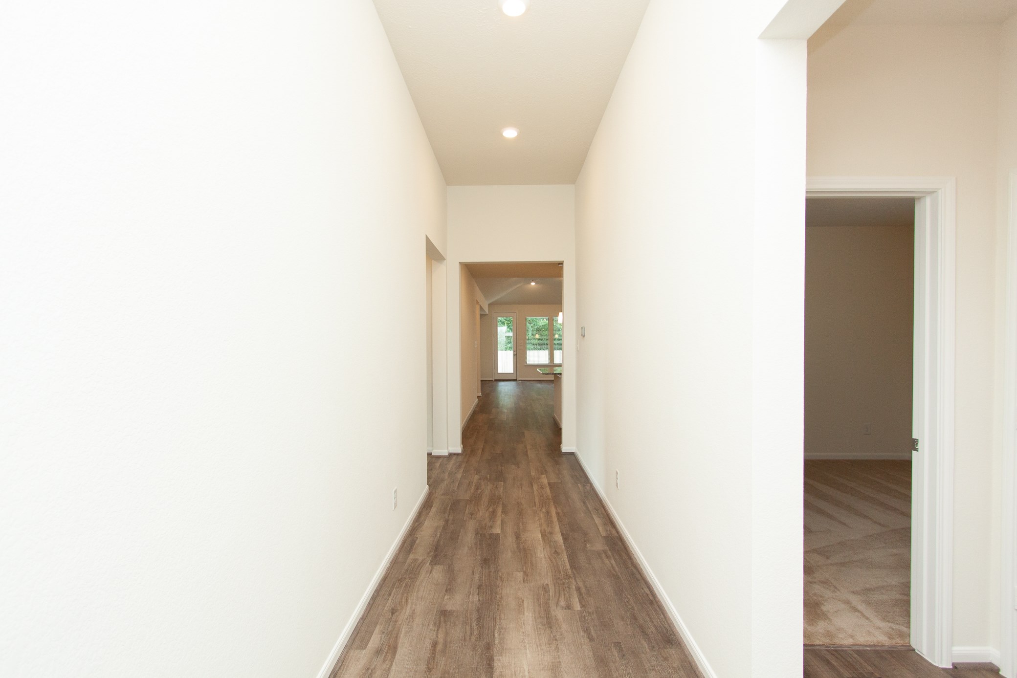 2011 Parnevik Place Conroe, TX 77304 - Photo 3 of 37 The view from the front door shows the wide and long stretch of hallway leading into the living space. The door to the right shows the third bedroom.