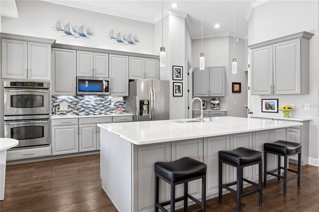 11325 Preston Cove Road Clermont, FL 34711 - Photo 14 of 58 a kitchen with stainless steel appliances a sink a stove a table and chairs