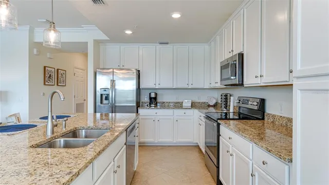 a kitchen with granite countertop a sink a stove and cabinets