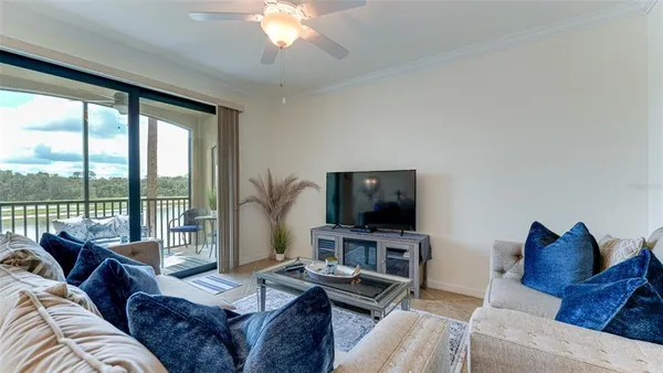 a living room with furniture a flat screen tv and a large window