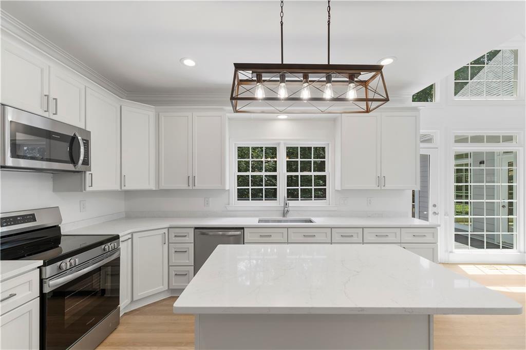 8965 Laurel Way Alpharetta, GA 30022 - Photo 15 of 79 a kitchen with a stove and a white cabinets
