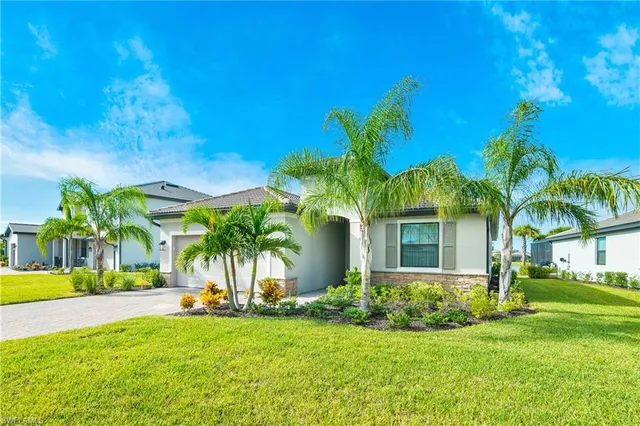 a view of a house with backyard and a tree