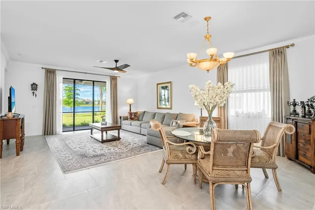 a dining room with wooden floor a chandelier a glass table and chairs