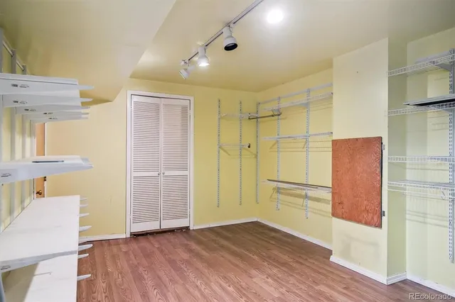 a view of walk in closet with wooden floor