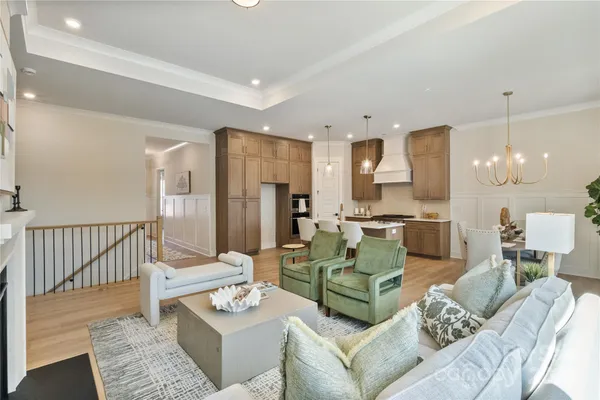 a living room with furniture and a dining table with kitchen view