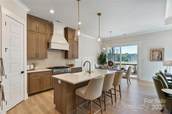 a kitchen with stainless steel appliances granite countertop a stove a sink a kitchen island with a dining table and chairs
