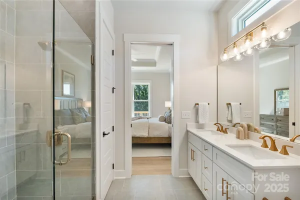 a en suite bathroom with a double vanity sink a mirror and a shower
