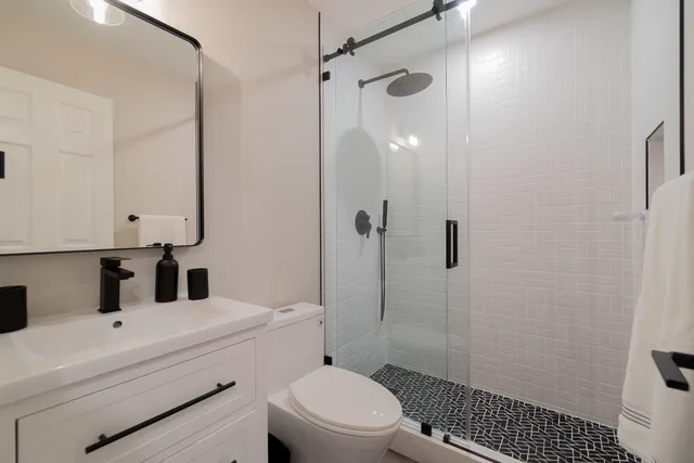 a bathroom with a sink toilet vanity and shower