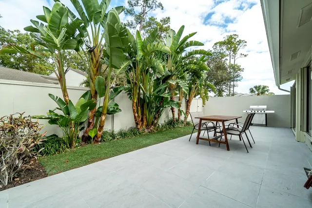 a view of a yard with a table and chairs in patio