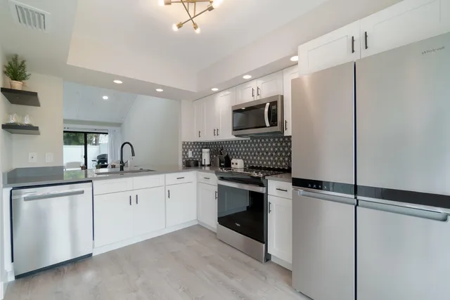 a kitchen with sink cabinets and stainless steel appliances