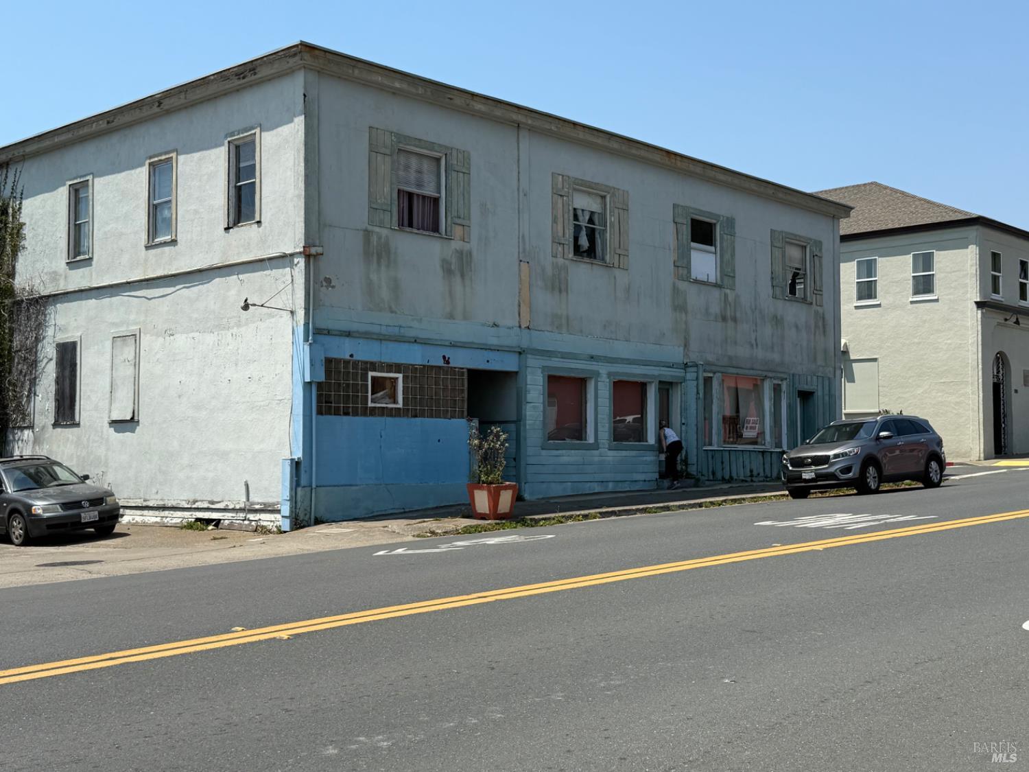 a view of a building with cars parked on road