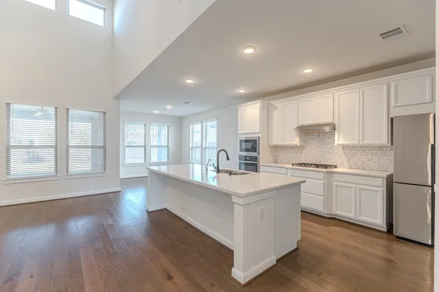 a view of kitchen with kitchen island and stainless steel appliances