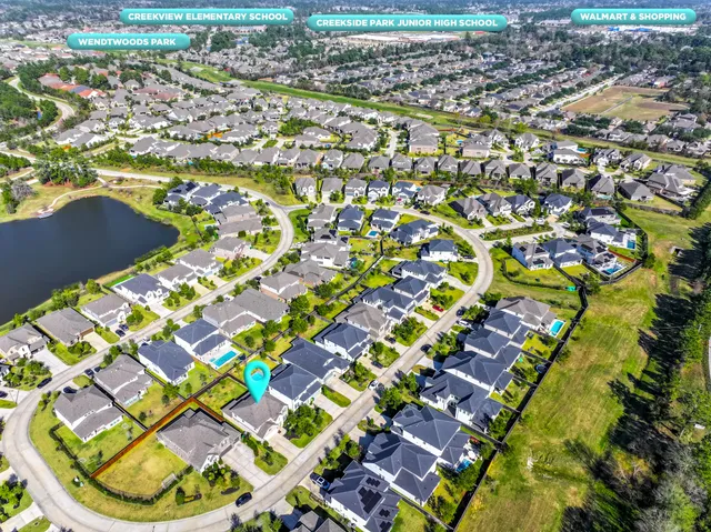 a large kitchen with stainless steel appliances a sink a stove a refrigerator and cabinets