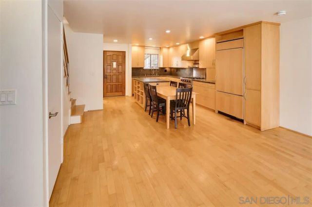 a view of a kitchen with furniture and a refrigerator