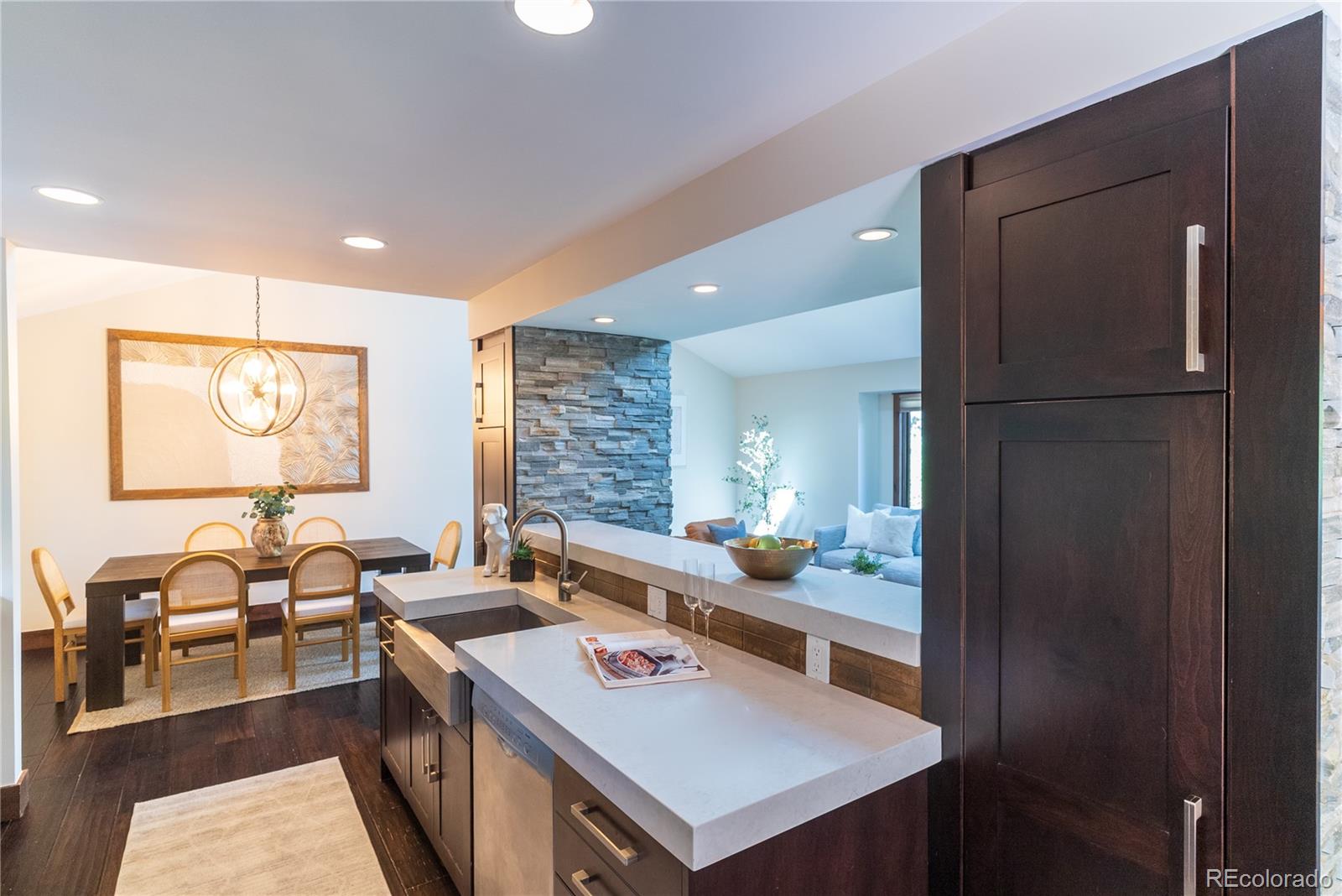 2464 Powderhorn Lane Boulder, CO 80305 - Photo 22 of 40 a kitchen with a refrigerator a stove and a dining table with wooden floor
