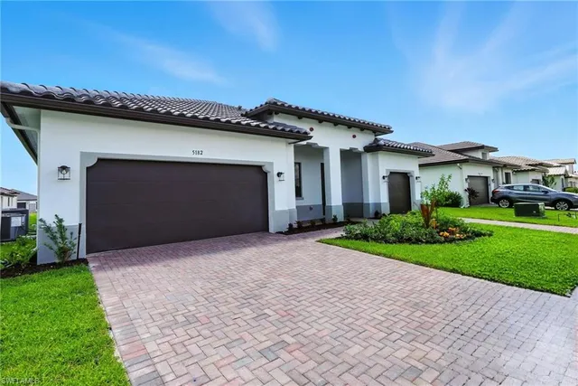 a front view of a house with a garden and garage