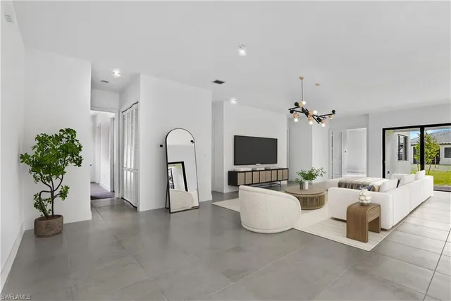 a living room with furniture a flat screen tv and a potted plant