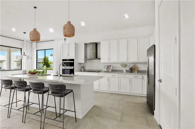 a kitchen with stainless steel appliances granite countertop a refrigerator a sink and a stove