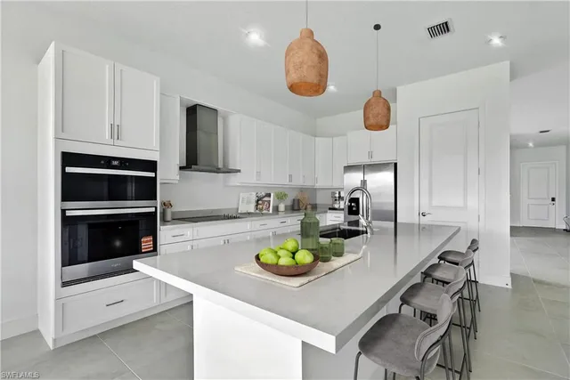 a kitchen with a stove a microwave and a dining table with wooden floor